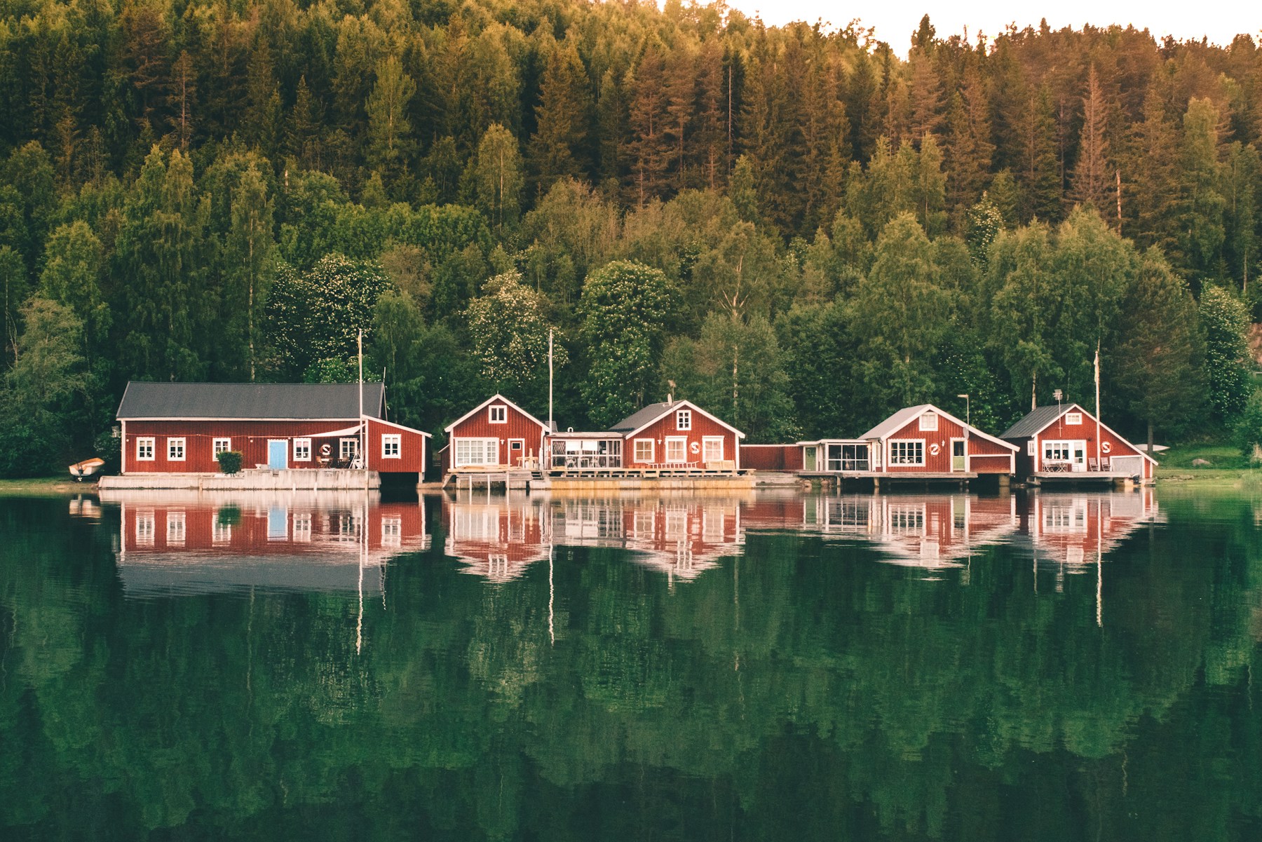 A row of red houses sitting on top of a lake
